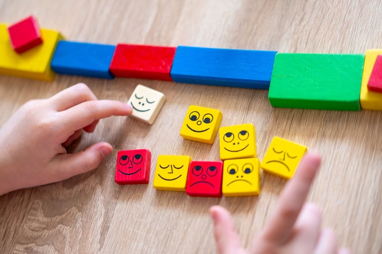 Wooden blocks with happy, sad emotions, preschool Child's hand playing with wooden blocks, emotional development through educational toys