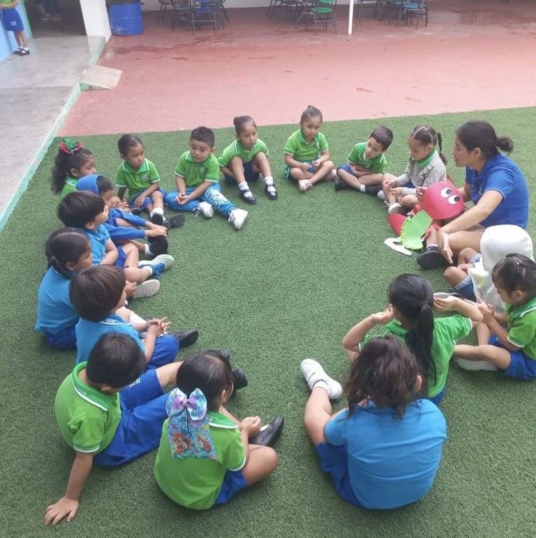 Group of children sitting in a circle on synthetic grass during an outdoor classroom activity or lesson