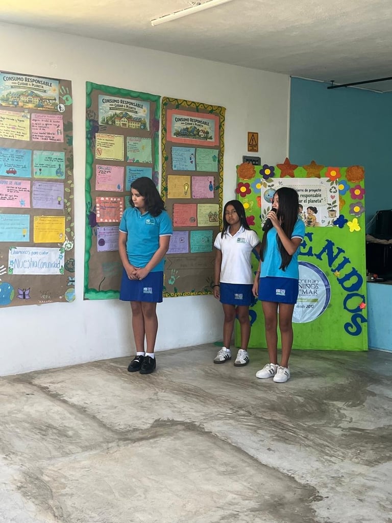 Three students in school uniforms standing in a classroom with colorful bulletin boards and educational displays on the walls