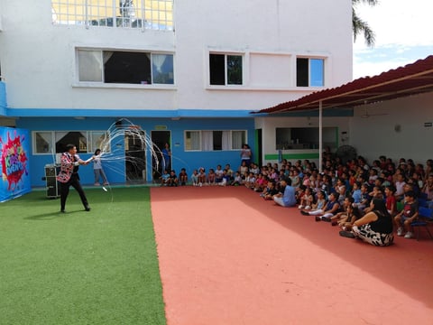 Artista con aros hula entreteniendo estudiantes